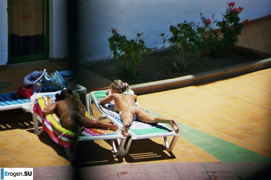 Girls sunbathe topless near the pool. Photo 21