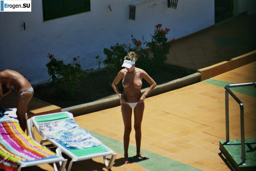 Girls sunbathe topless near the pool. Photo 23