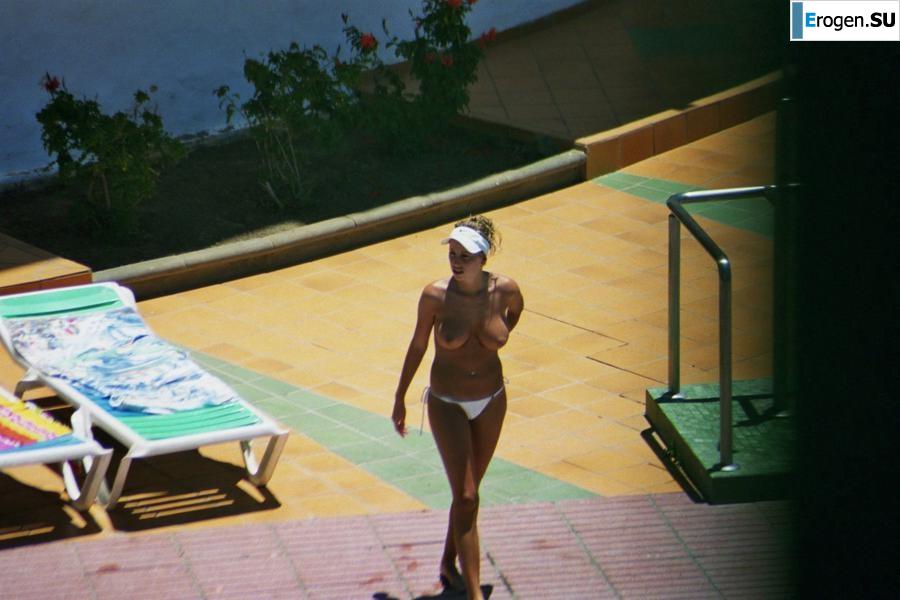 Girls sunbathe topless near the pool. Photo 25