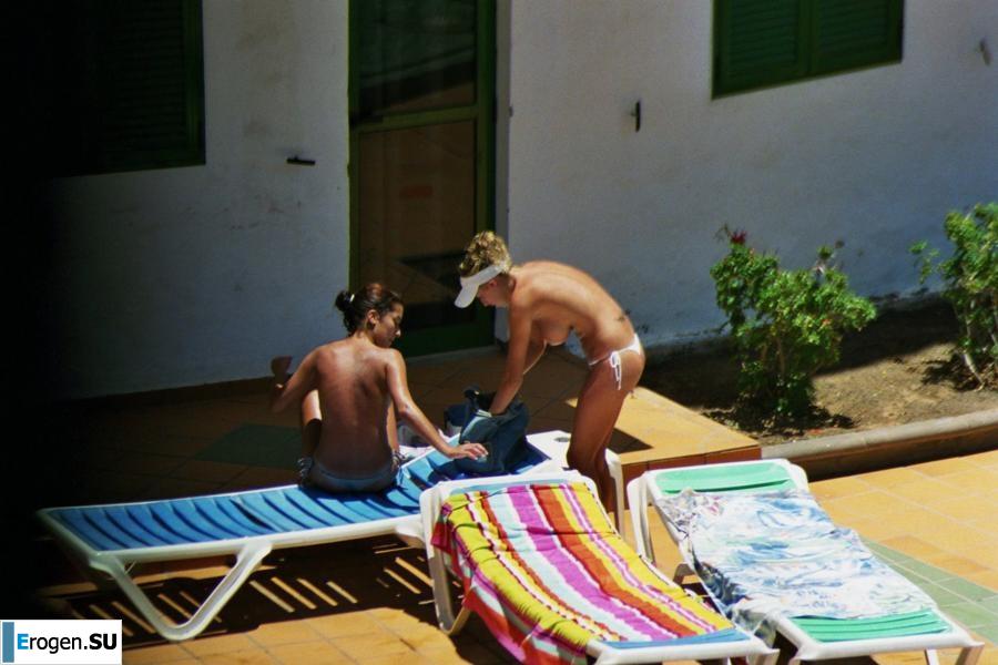 Girls sunbathe topless near the pool. Photo 30