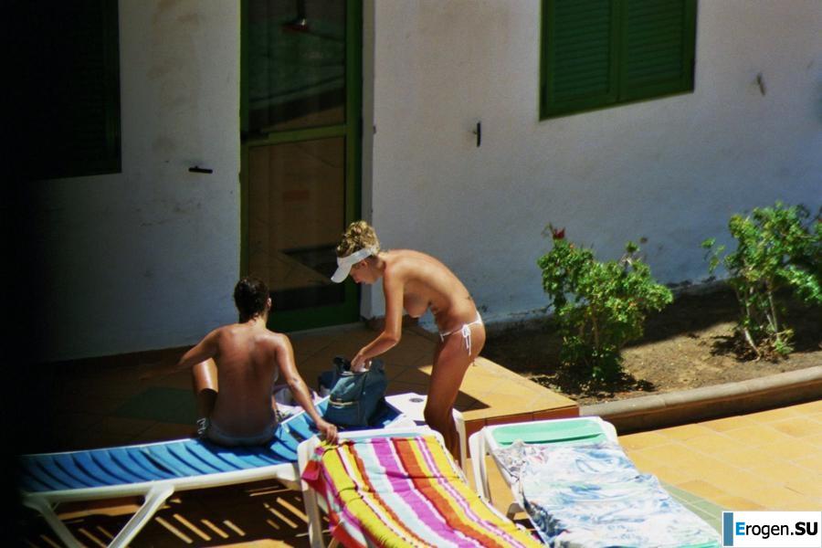 Girls sunbathe topless near the pool. Photo 31