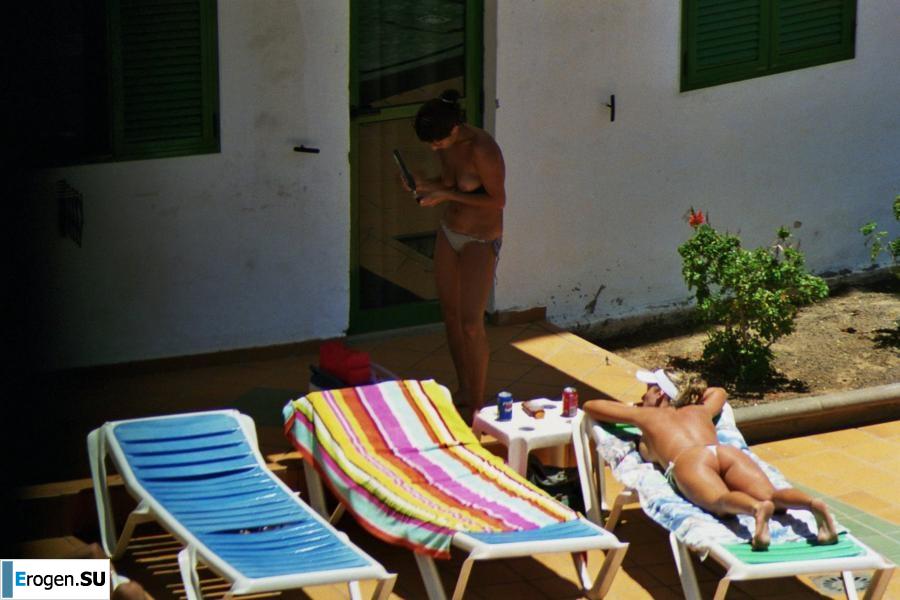 Girls sunbathe topless near the pool. Photo 35