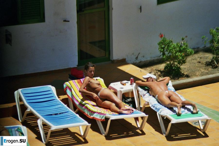 Girls sunbathe topless near the pool. Photo 36