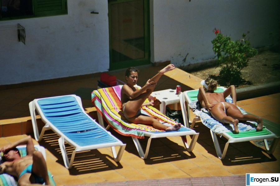 Girls sunbathe topless near the pool. Photo 37
