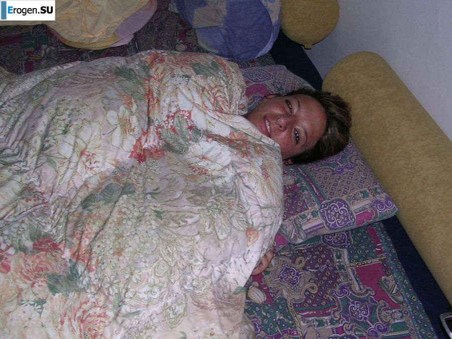 A tanned brunette shines her tits in the morning in bed. Photo 9