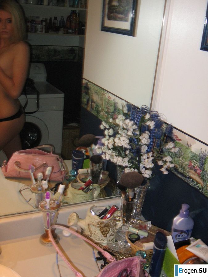 Chic blonde poses without a bra in the bathroom in front of the mirror. Photo 11