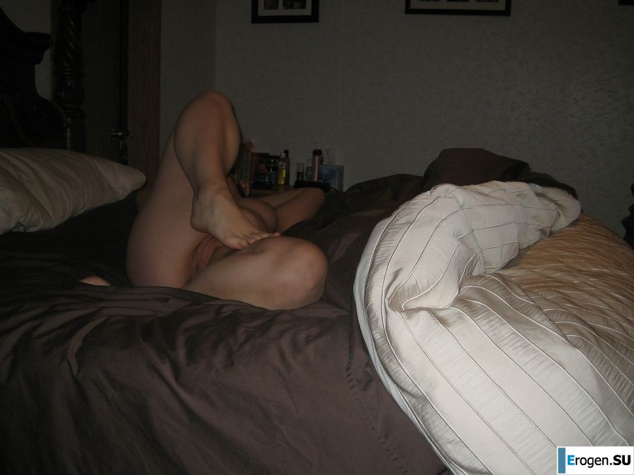 A naked woman is lying on the bed and wrinkling her boobs. Photo 12